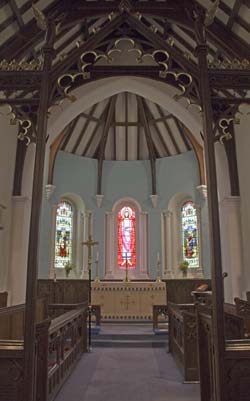 View of the interior of the church, showing some of the stained glass in the chancel.